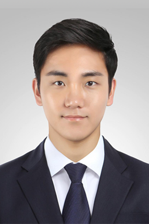 Portrait of a young Asian man in a navy suit and tie, facing forward against a light gray background.